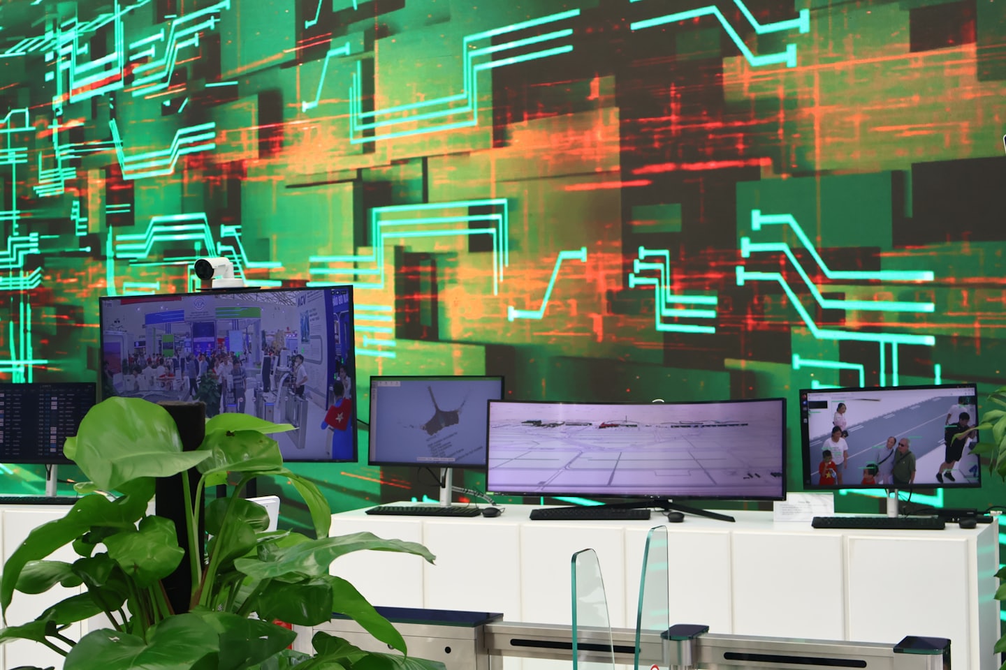 Varias pantallas digitales muestran imágenes de seguridad y mapas en una sala de control.
